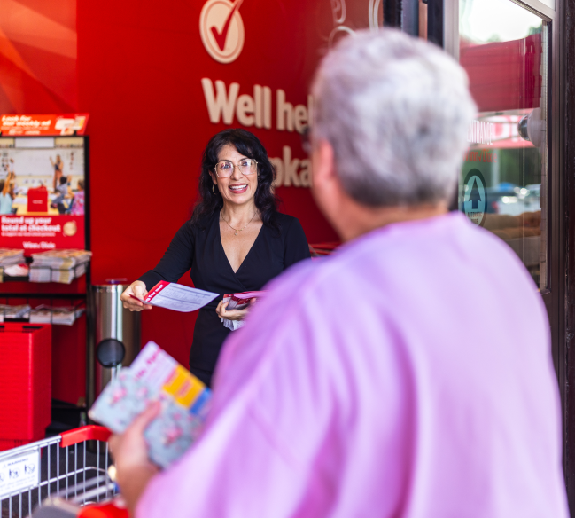 A Winn-Dixie employee hands out a flyer to a shopper